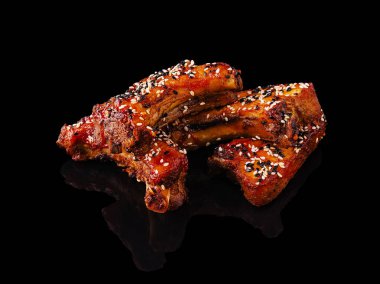 Lezzetli ızgara domuz pirzolası çok güzel sunulur, üzerine susam tohumları eklenir. Zengin renk ve doku, et severler için lezzetli bir yemek deneyimi vadediyor..