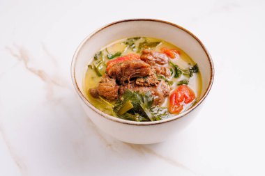 Yürekli bir kuzu güveci yumuşak et parçaları, taze yeşiller ve canlı domatesler içerir. Yemek lezzet bakımından zengindir. Sıcak ve davetkar bir yemek sunar. Her duruma uygun..