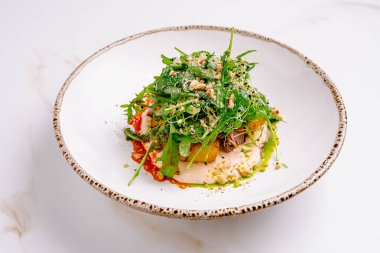 Taze bir salatada canlı yeşillikler, renkli sebzeler ve pürüzsüz bir sos serpiştirilmiş fındıklar bulunur. Güzelce sunulduğunda, bir mutfak başyapıtı sergiliyor..