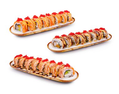 Üç çeşit suşi rulosu uzun ve kıvrımlı tabaklarda ustalıkla düzenlenir. Her rulo canlı balık yumurtası ile kaplanmış, çeşitli doku ve renkler sergileniyor..