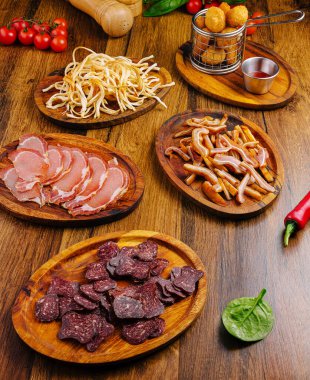 Tahta tahtalarda çeşitli pişmiş etler, çıtır çıtır atıştırmalıklar ve taze malzemeler sergileniyor. Toplantılar için mükemmel, bu renkli çeşitlilikte çeşitli tatlar var..