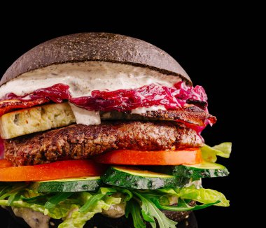 Lezzetli bir gurme hamburgerinde sulu köfte, çıtır pastırma, taze marul, domates ve kremalı sos bulunur..