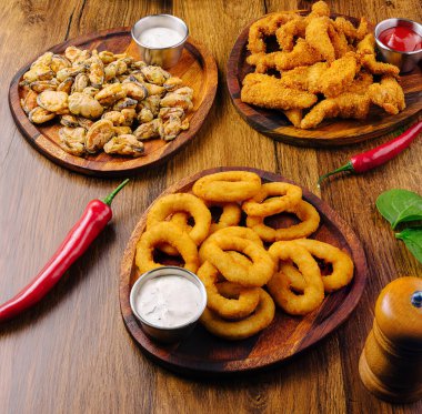 Çıtır soğan halkalarının yanında istiridye ve balık filetosu da dahil olmak üzere çeşitli kızarmış deniz ürünleri sunuluyor. Batırma sosları metal bardaklarda servis edilir, yemeğe tat katar..