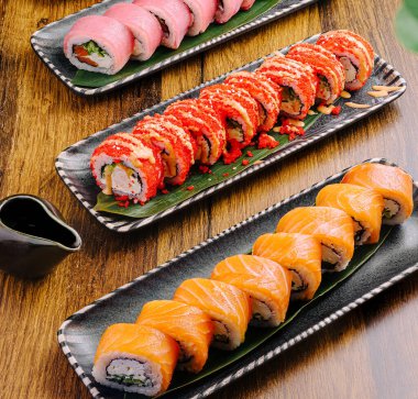 Zarif tabaklarda renkli suşi ruloları sunuluyor..