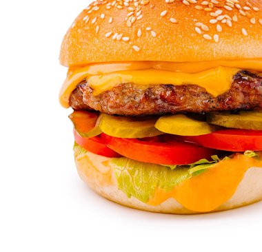 Ağız sulandıran bir çizburger temiz bir yüzeye yerleştirilir. Hamburgerde sulu bir biftek köftesi, erimiş peynir, taze marul, domates dilimleri ve susamlı çöreğin içine yerleştirilmiş turşular yer alıyor..