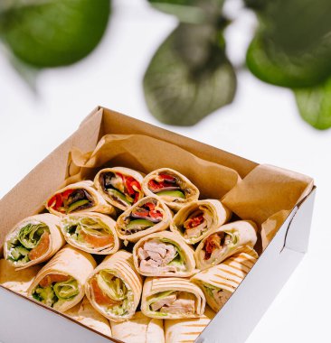 Renkli dolguları olan iştah açıcı taze paketler paket kutusunda güzelce düzenlenir. Arka plan minimalistik, lezzetli yiyeceklere odaklı, sağlıklı bir yemek için ideal..