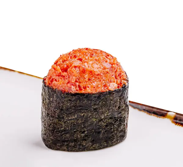 Lezzetli suşi rulosu, deniz yosunlarına sarılı taze deniz ürünleri ile yapılmış beyaz bir tabakta duruyor, bir lokantada tadını çıkarmaya hazır. Canlı renkler tazeliğini vurgular.