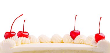 Beyaz bir pasta güzel bir şekilde krem şanti ve parlak kırmızı kirazlarla süslenir. Dekor basit ve zarif görünüyor. Tatlıyı sade bir arkaplanda öne çıkarıyor..