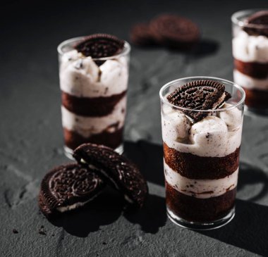 Zengin çikolatalı pasta ve kremalı dolgu, kurabiye parçaları ve kurabiyelerle süslenmiş cazip bir tatlı yaratır. Tatlı meraklıları için her zaman mükemmel..