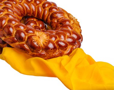 Çok güzel işlenmiş dairesel bir ekmek canlı sarı bir kumaşın yanında sergileniyor, şenlik ortamları için mükemmel. Bu geleneksel ekmek genellikle kültürel kutlamalar ve toplantılar sırasında beğenilir..