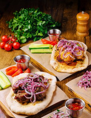 Flatekmeler güzel bir şekilde ızgara etle sunulur, soğanla süslenir ve taze sebze ve sosla servis edilir. Bu canlı yemek zengin bir mutfak geleneğini ön plana çıkarıyor..