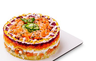 Güzel hazırlanmış katmanlı bir kek rengarenk sebzelerle karıştırılmış ve krem peynirle kaplanmış somon dilimlerine sahiptir. Canlı katmanlar büyüleyici bir görsel ziyafet yaratıyor..