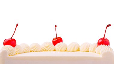 Çok güzel işlenmiş beyaz bir pasta krem şanti ve kiraz kıvrımlarıyla süslenmiş pürüzsüz krema içerir. Kutlama için ideal, bu tatlı çekici ve lezzetli görünüyor..