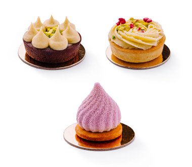 Tek tek tezgahlarda üç adet güzel yapılmış kek düzenleniyor. Her kek farklı tasarım ve renklere sahiptir, çeşitli kaplama teknikleri ve malzemeler sergilenir..