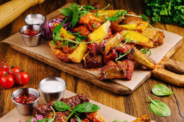 Kızarmış patateslerin yanında lezzetli ızgara etlerin de olduğu canlı bir yemek. Taze sebzeler ve soslar, zengin bir aşçılık deneyimi sunan doyurucu yemeği tamamlıyor..