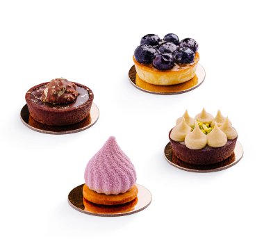 Dairesel temellerde dört eşsiz tatlı sergilenir. Her tedavi farklı tat ve dokulara sahiptir, parlak bir ortamda yaban mersini, çikolata ve kremalı malzemeler vurgulanır..