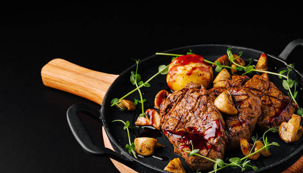 Tender grilled steak is beautifully arranged with sauted mushrooms and roasted potatoes in a cast iron skillet