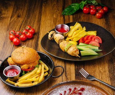 Ağız sulandırıcı vitrinler kızarmış tavuk şişleri ve ahşap bir masada taze sebzelerin yanında gevrek bir burger. Sıradan bir yemek için mükemmel..