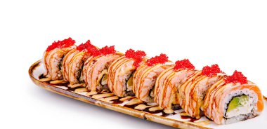 Çok güzel düzenlenmiş bir suşi tabağında somon ve krem peynirle dolu rulolar, üzerinde kırmızı havyar ve bir tutam sos var. Suşi restoranında paylaşmak için mükemmel..