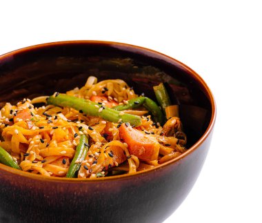 Renkli sebzeler ve susam tohumlarının yer aldığı canlı bir sebze kızartması koyu ahşap bir kasede servis edilir. Taze malzemeler her yemek için mükemmel bir iştah açıcı ve sağlıklı yemek yaratır..