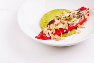 Canlı bir kırmızı biber lezzetli bir dolma ile doldurulur ve parlak yeşil bir sosun üzerinde duran kızarmış badem taneleriyle süslenir. Yemekler mutfağın yaratıcılığını ve zarafetini gözler önüne seriyor..