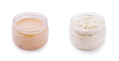 İki cam kavanoz farklı kremalı soslar içeriyor. Bir kavanozda ince benekli pembemsi bir sos, diğerinde ise çeşitli tabakları geliştiren şifalı otlardan oluşan beyaz bir sos var..