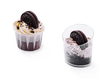 Canlı ve parlak bir ortamda sunulmuş iki tatlı seçeneği sergilenen kremalı ve çikolatalı kurabiye malzemesi. Biri kremalı kek, diğeri ise bir bardakta..