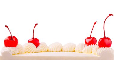 Vanilyalı bir tatlı kabarık krema ve parlak kırmızı kirazlarla kaplıdır. Basit ama klasik süsleme tatlılığa ve çekiciliğe bir dokunuş katar..