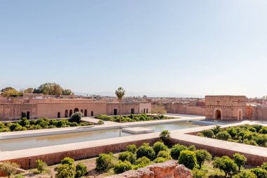 Marakeş 'teki Badi Sarayı' nın önünde su birikintisi, arkasında turistler var.