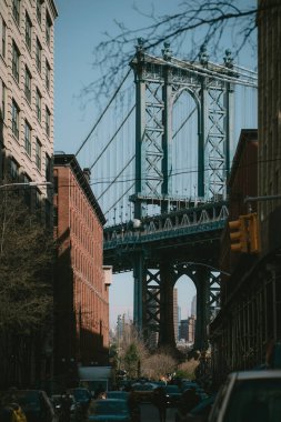 Canlı bir şehrin çalkantılı ortamında iki farklı binayı birbirine bağlayan belirgin bir şekilde görülebilir bir köprü.