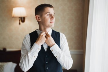 Güzel adam, damat poz veriyor ve düğüne hazırlanıyor..