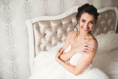 Beyaz elbiseli lüks gelin düğün törenine hazırlanırken poz veriyor..