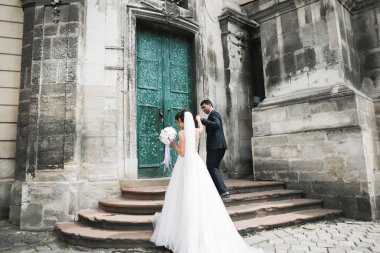 Güzel, mutlu bir düğün çifti, güzel şehirde uzun beyaz elbiseli bir gelin..