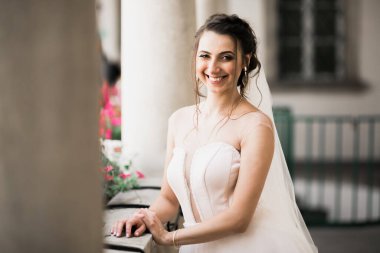 Çekici gelinin portresi, uzun saçlı, büyük buketli poz veren..