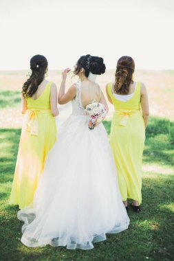 Gelin çiçekli büyük ve güzel bir düğün buketi tutuyor..