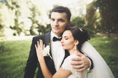 Mutlu düğün çift büyüleyici damat ve mükemmel gelin parkta poz.