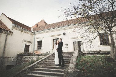 Güzel, romantik bir düğün. Yeni evliler. Eski kalenin yakınlarında sarılıyorlar..