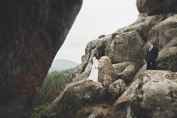 山の中で美しい風景の上にポーズ幸せな結婚式のカップル — ストック写真