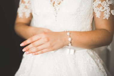 Cüppeli muhteşem gelin bir odada düğün töreni için poz veriyor ve hazırlanıyor..