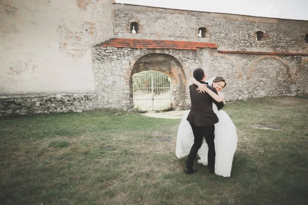 美丽的童话新婚夫妇拥抱在古老的中世纪城堡附近 — 图库照片