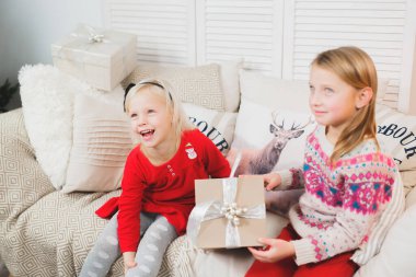 Sihirli hediye kutusu ve küçük bir kız bebek, Noel mucizesi, küçük mutlu, mutlu bir kız hediyelerle dolu bir kutuyu açıyor..