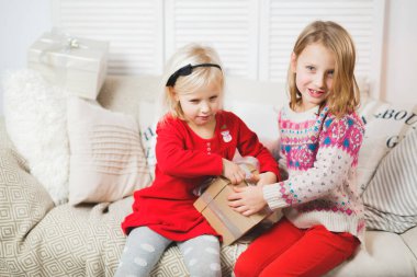 Sihirli hediye kutusu ve küçük bir kız bebek, Noel mucizesi, küçük mutlu, mutlu bir kız hediyelerle dolu bir kutuyu açıyor..