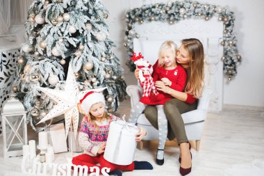 Anne ve kızları küçük kızların doğum günü hediyelerini açıyorlar..