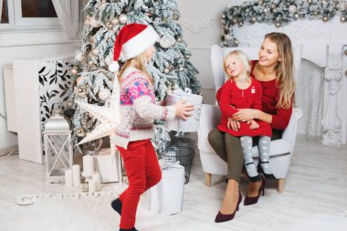 Anne ve çocukları Noel ağacının yanında kutluyorlar..