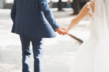 Gelin ve damat el ele tutuşuyor..