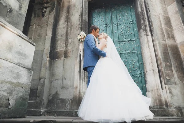 素敵な幸せな結婚式のカップル 美しい街でポーズをとる長い白いドレスの花嫁 — ストック写真