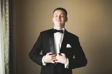 Güzel adam, damat poz veriyor ve düğüne hazırlanıyor..