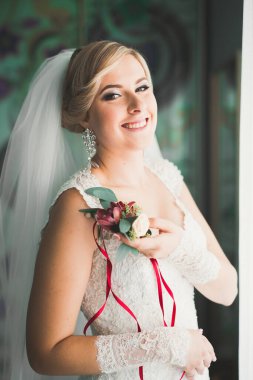 Beyaz elbiseli lüks gelin düğün törenine hazırlanırken poz veriyor..