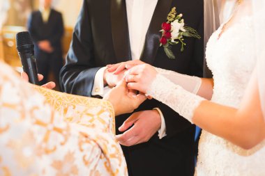 Gelin ve damat alyanslarını değiş tokuş ediyorlar. Şık bir çift töreni..