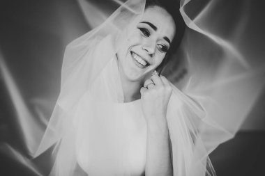 Cüppeli muhteşem gelin bir odada düğün töreni için poz veriyor ve hazırlanıyor..